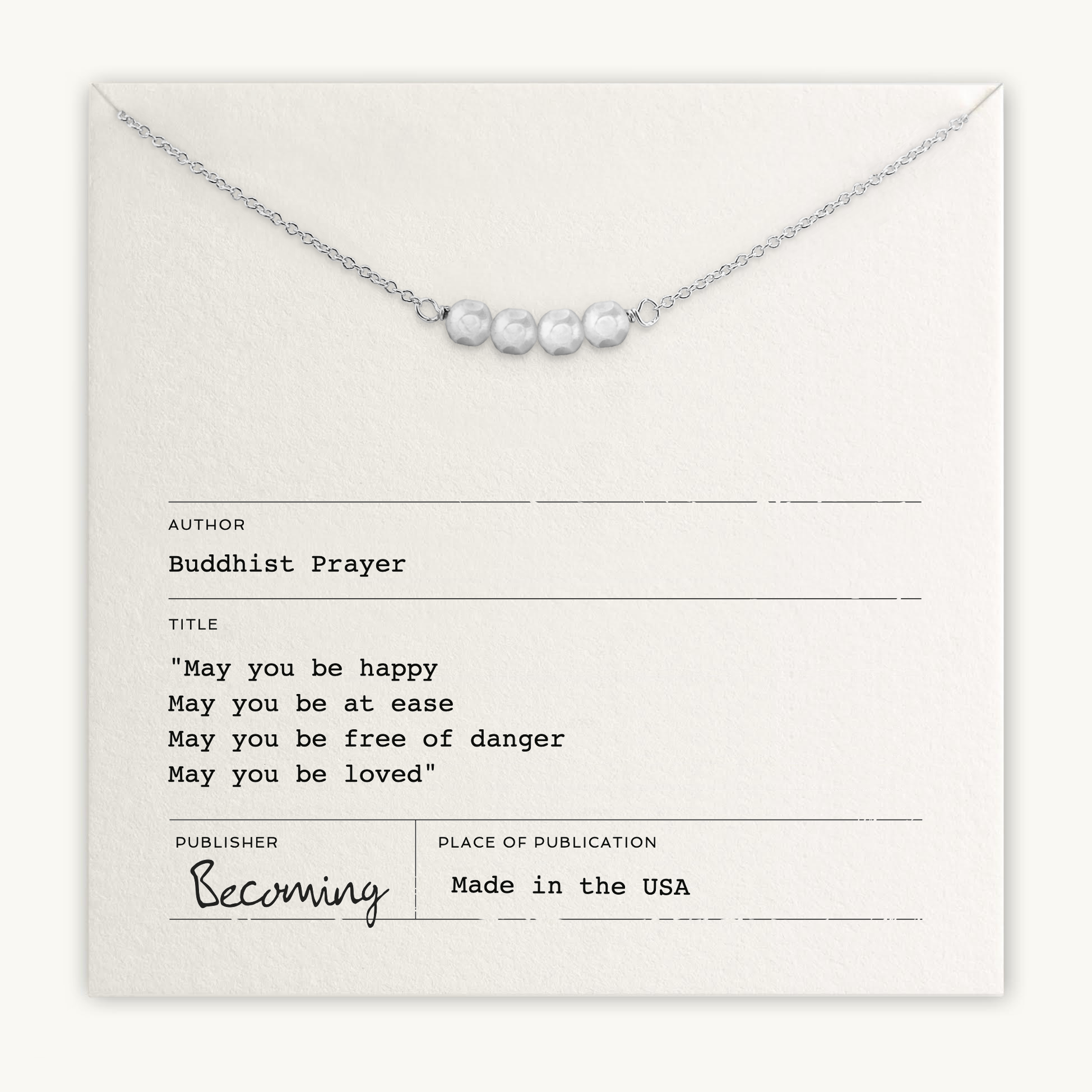 The May You Be Happy Necklace by Becoming Jewelry features pearl-like beads on a card with a Buddhist prayer for happiness, health, safety, and love.