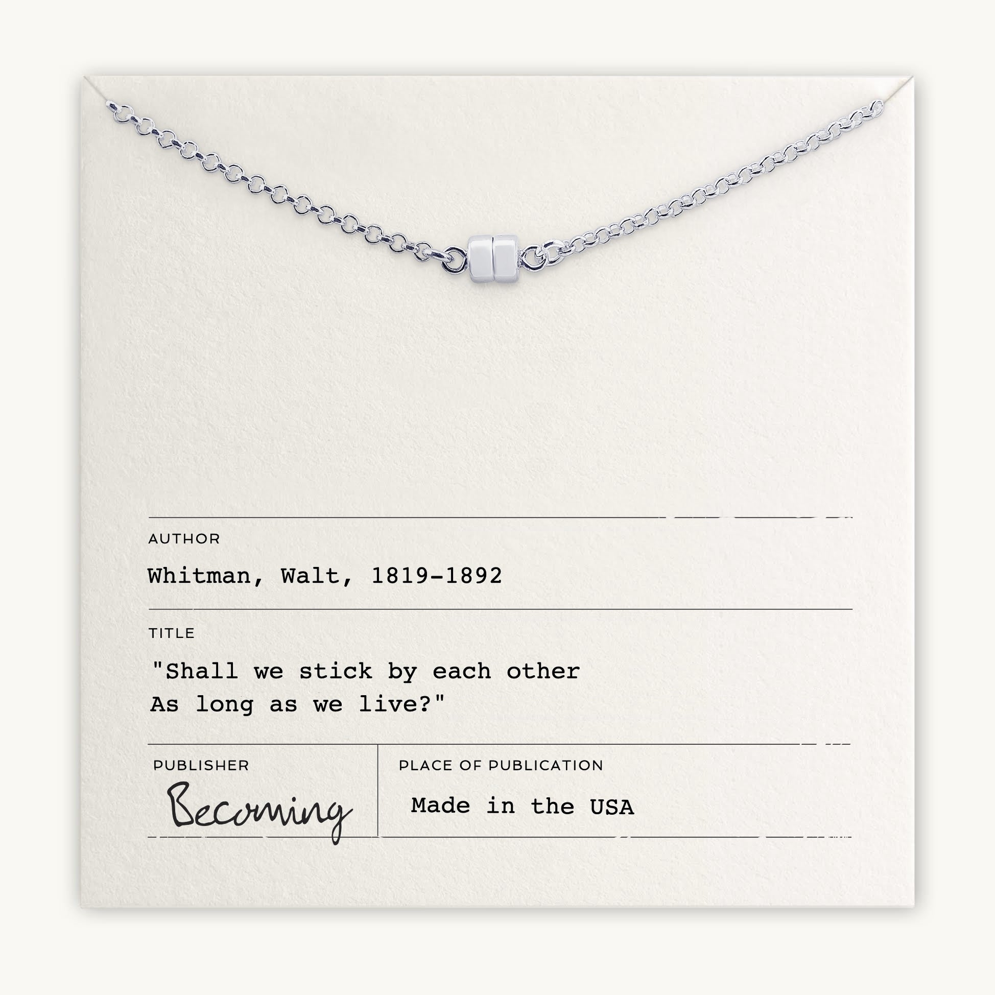 The Stick Together Necklace from Becoming Jewelry highlights a silver charm presented on a card with Walt Whitman's quote, "Shall we stick by each other As long as we live?" It celebrates meaningful connections and includes information about the author, title, publisher, and place of publication.