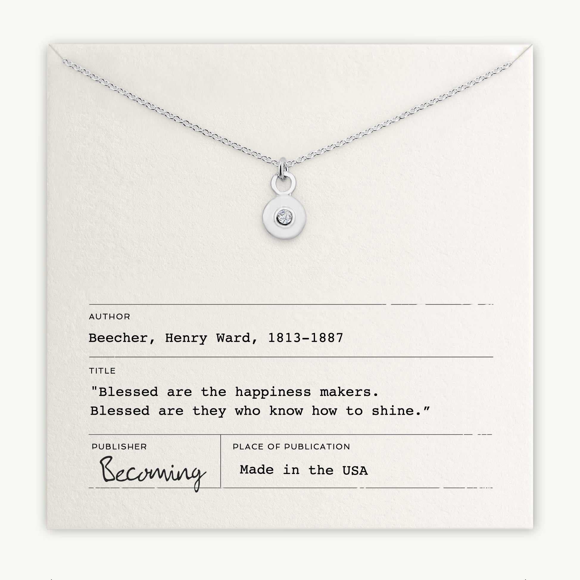 A silver Shine Necklace from Becoming Jewelry, featuring a circular pendant with a sparkling Cubic Zirconia gem in the center, is displayed on a note showcasing a quote by Henry Ward Beecher.